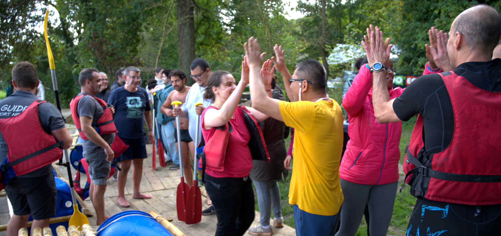 Participants se félicitant après une activité de cohésion en canoë organisée par Rando’Events